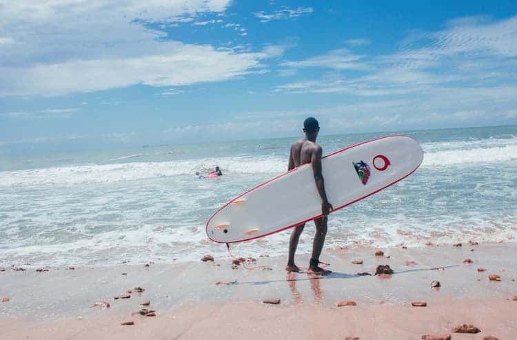 Surfer op het strand in Ghana